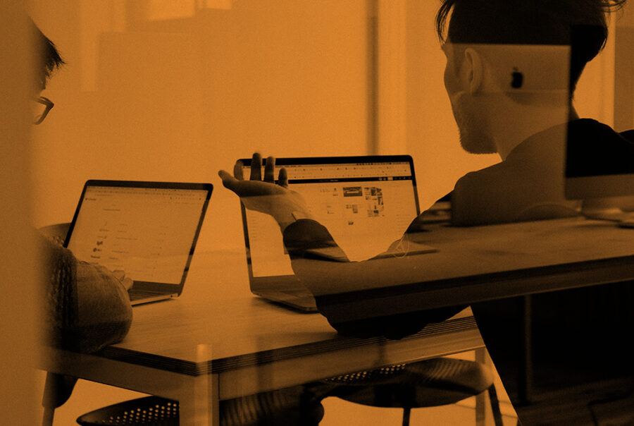 Person working on laptop at desk, focused on business performance.