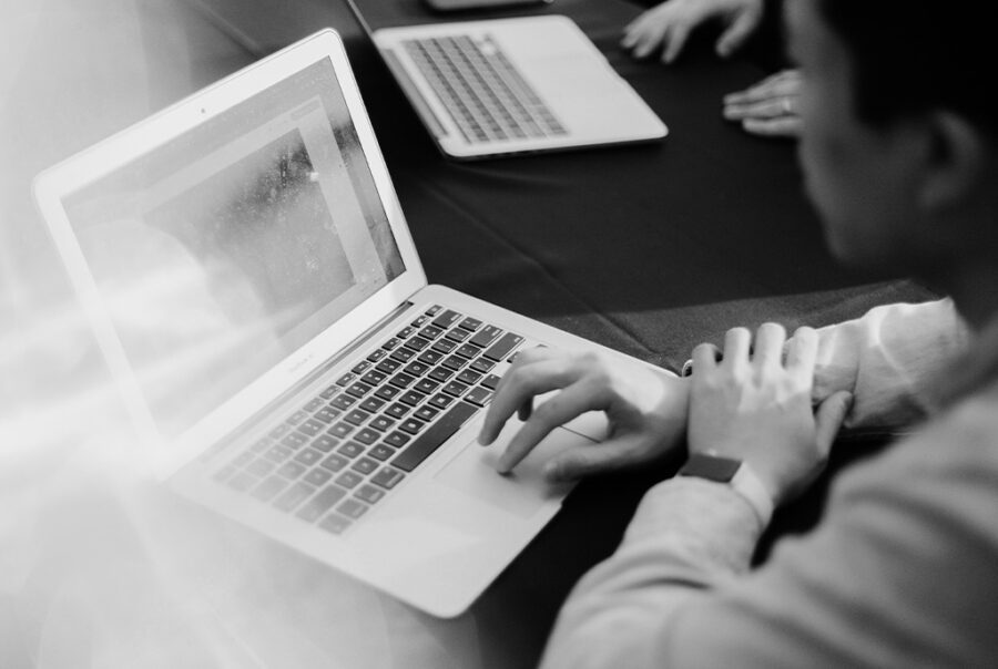Hands typing on a laptop, depicting online Christian business collaboration.